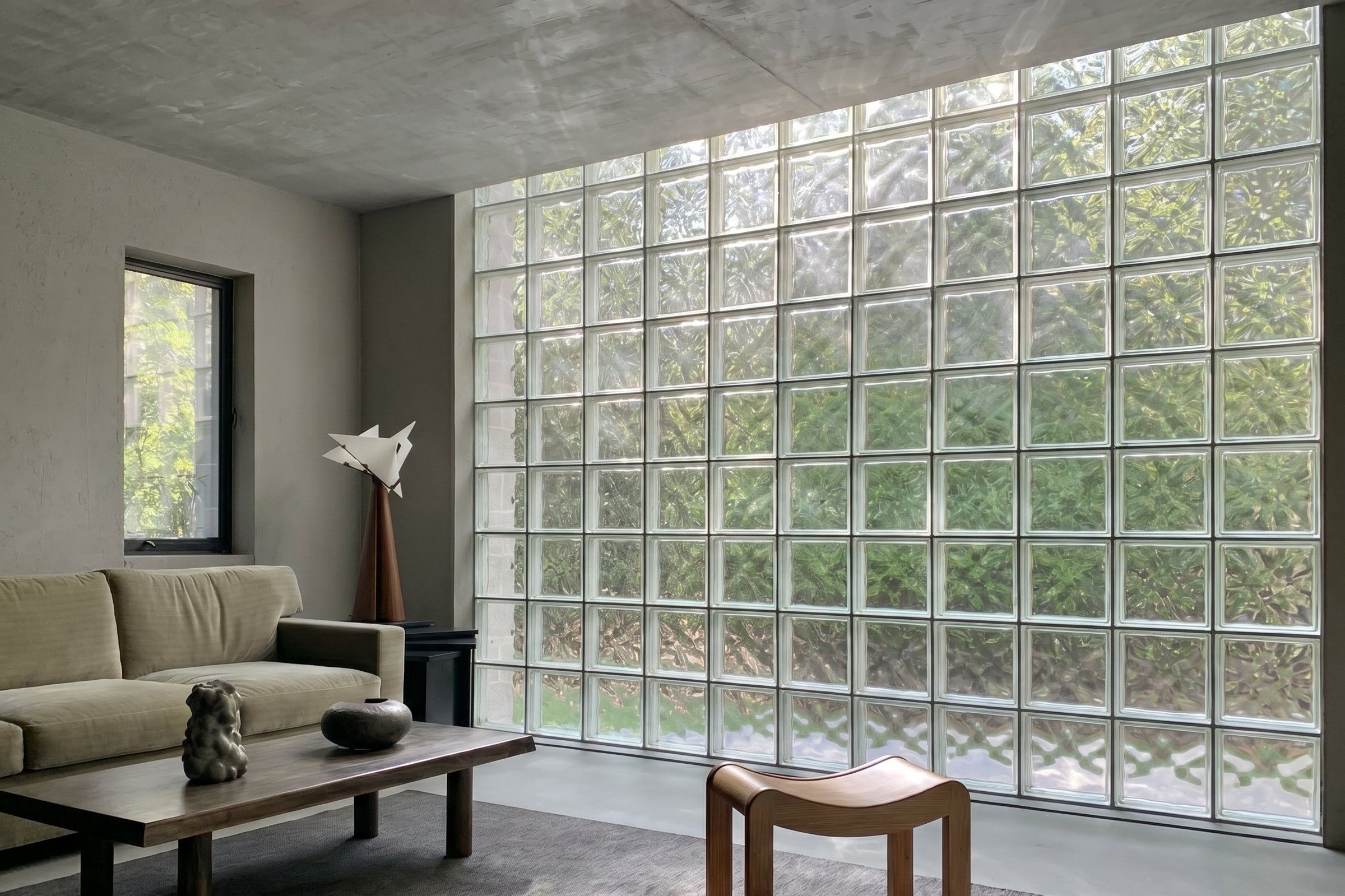 Detail dinding glass block modern dengan efek cahaya yang masuk ke dalam ruang.